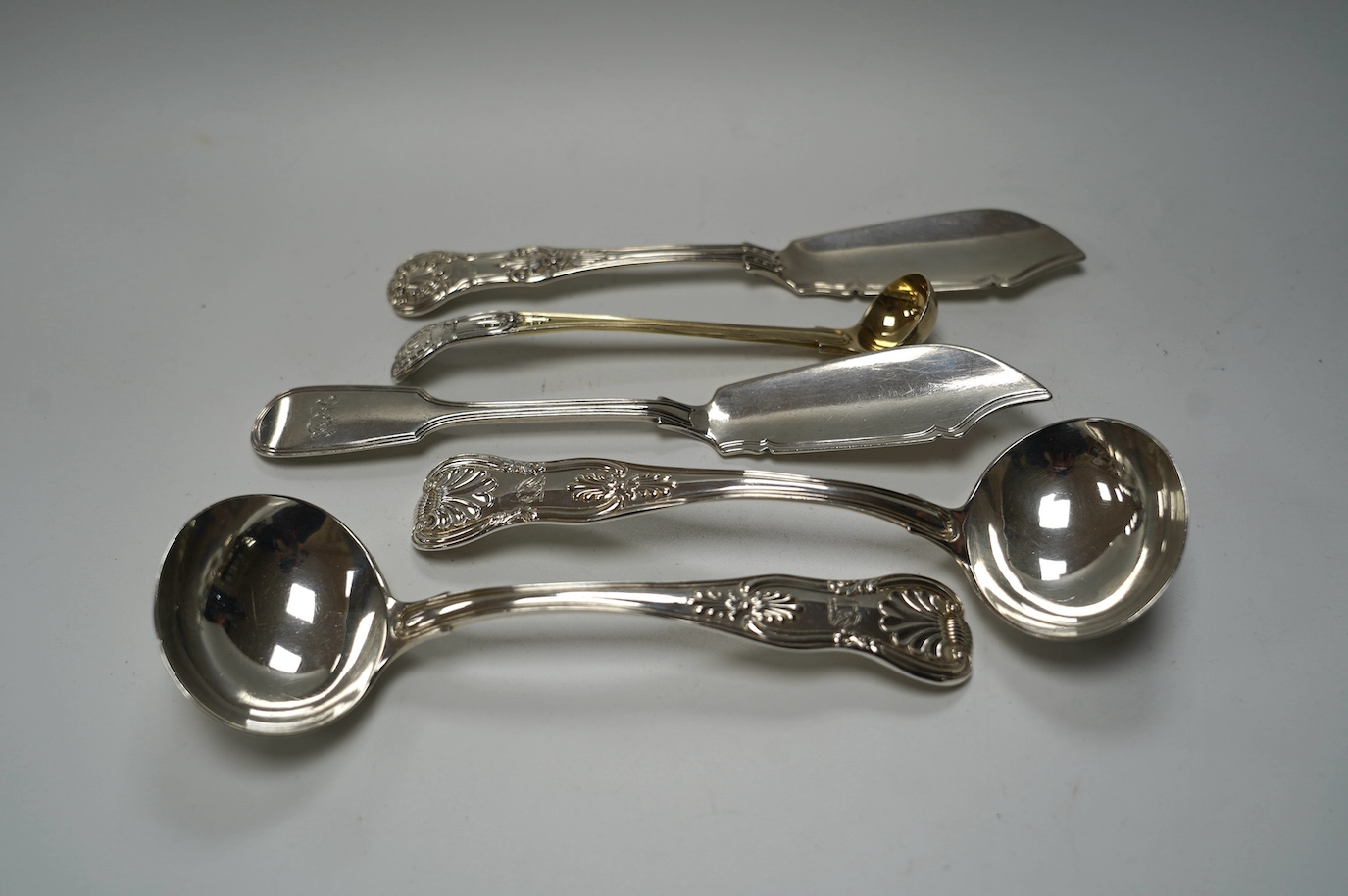 A pair of George IV silver King's pattern sauce ladles, by William Eaton, London, 1824, 17.5cm, two Victorian silver butter knives and a Victorian silver condiment spoon, 13.7cm, 10.5oz. Condition - fair to good